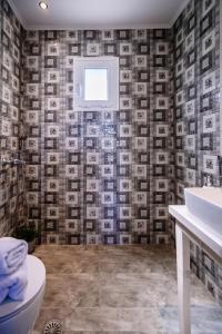 a bathroom with a toilet and a tv on the wall at Villy Suites in Argassi