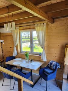 ein Esszimmer mit einem Tisch und blauen Stühlen in der Unterkunft Jaśkowe Wzgórze domki na wynajem, balia, Szymbark DOMEK NR 1 in Szymbark