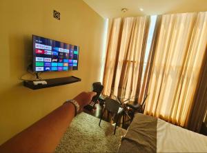 a person holding a microphone in a room with a television at Greenwindows Hotel in Davao City