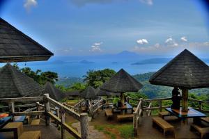 a view of a resort with tables and umbrellas at Chill @ 10f Tagaytay-2BR+Balcony w/ Panoramic View in Tagaytay