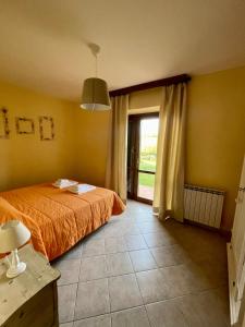 a bedroom with a bed and a large window at I Puntoni Agriturismo in Magliano in Toscana