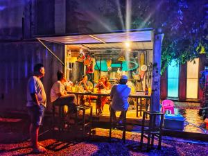 a group of people sitting at a table outside a food truck at seds kanchanaburi in Ban Chuk Kum
