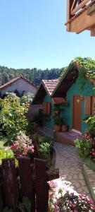 una casa con un jardín con flores delante en Casa Moreira´s Chalés, en Monte Verde