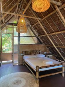 a room with a bed and a chandelier at Kasa Raya By The Sea in Tibiao