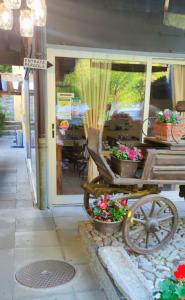 uma carruagem com vasos de flores à porta de uma loja em OSTERIA RUBINO DA PAOLO em Acquarossa