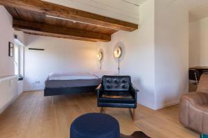 una camera con letto, sedia e divano di Dachstuv von Esmarch a Tönning