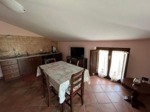 eine Küche mit einem Tisch und einem weißen Tischtuch in der Unterkunft Casa Vacanze Vecchio Frantoio Residenza Leccino in Spoleto