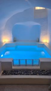 una vasca idromassaggio blu in una stanza con rocce di Loveroom La Cesarine Jacuzzi privé a Mougins