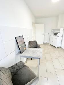 een woonkamer met een tafel en een stoel bij City Loft in Toplage Mainz-Kastel in Wiesbaden