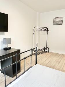 a white room with a bed and a television at City Loft in Toplage Mainz-Kastel in Wiesbaden