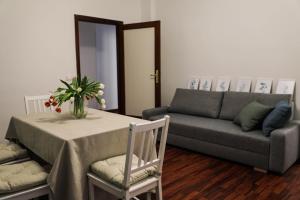 a living room with a table and a couch at Aura Home rent of rooms with shared kitchen in Bari