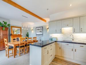a kitchen and dining room with white cabinets and a table at Number 10 in Dartmouth