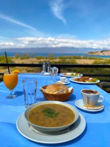 a blue table topped with bowls of soup and drinks at Villa Megdani B in Ohrid