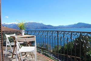 a balcony with a table and chairs and a view of the water at B&B Nonno Leo in Cannero Riviera