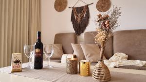 einen Tisch mit einer Flasche Wein und zwei Gläsern in der Unterkunft Desert Call in Arad