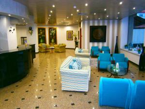a lobby with couches and blue chairs at Hotel Cristal Caldas in Caldas da Rainha