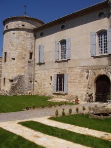a large stone building with a clock tower at Chateau de la Bastide in Goudargues