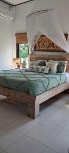 ein großes Bett mit Baldachin in einem Zimmer in der Unterkunft Villa Gede Private Guest House in Selemadeg