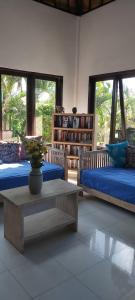 a living room with two beds and a coffee table at Villa Gede Private Guest House in Selemadeg