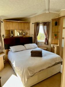 a bedroom with a bed with two towels on it at Cragside View Lodge in Newton on the Moor