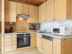 a kitchen with wooden cabinets and a microwave at Modern Holiday Home in Sankt Georgen with Swimming Pool in Sankt Lorenzen ob Murau