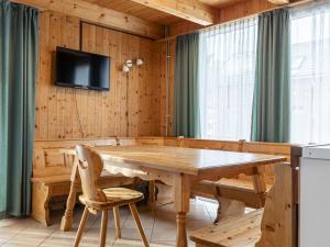 a dining room with a wooden table and a tv on a wall at Modern Holiday Home in Sankt Georgen with Swimming Pool in Sankt Lorenzen ob Murau
