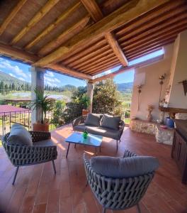 a patio with a couch and chairs and a table at Agriturismo Montefabbrello in Magazzini