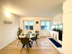 cocina y comedor con mesa y sillas en GLAD Spot - Liestal - 10 min from Basel - Central, Design & Netflix, en Liestal