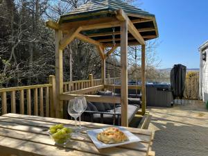 a gazebo on a deck with a table with a wine glass at Cragside View Lodge in Newton on the Moor