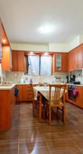 a kitchen with wooden cabinets and a table and chairs at Alice house 3 in Amarynthos