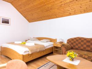 een slaapkamer met een bed, een bank en een tafel bij Villa Tatry Stola in Štôla