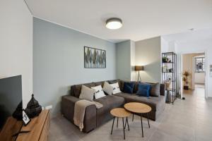ein Wohnzimmer mit einer Couch und zwei Tischen in der Unterkunft smooth living Apartments Augsburg Lechhausen - Free parking in Augsburg