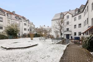 a snow covered street in a city with buildings at smooth living Apartments Augsburg Lechhausen - Free parking in Augsburg