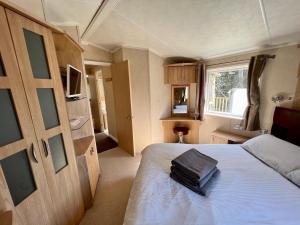 a bedroom with a bed and a window at Cragside View Lodge in Newton on the Moor