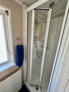 a shower with a glass door in a bathroom at Cragside View Lodge in Newton on the Moor