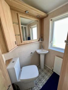 a small bathroom with a toilet and a sink at Cragside View Lodge in Newton on the Moor