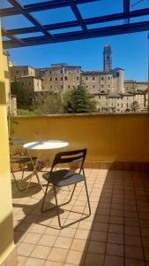 two chairs and a table on a balcony with a building at Fontecorona Bed and Breakfast in Serra San Quirico