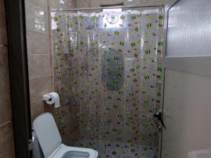 a bathroom with a shower curtain with a toilet at family studio in Wadi Musa