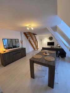 a living room with a table and a staircase at QUAI 65 , 3 pièces sur le port, à 250 m de la rue piétonne et de la mer in Dieppe