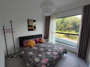 um quarto com uma cama e uma grande janela em The Grand Homestay ッ em Sandakan