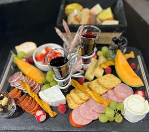 a tray of food with two glasses of wine and appetizers at Dôme S'féérique avec accès piscine in Saint-Évarzec