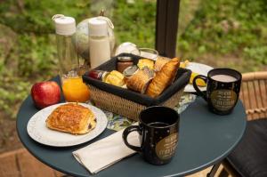 a table with a basket of breakfast foods and coffee at Logement insolite "Bubble jungle" in Saint-Évarzec