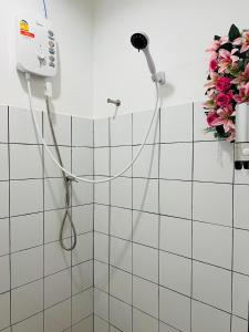 La salle de bains carrelée de blanc est pourvue d'une douche et de fleurs. dans l'établissement Cannabitel, à Haad Rin