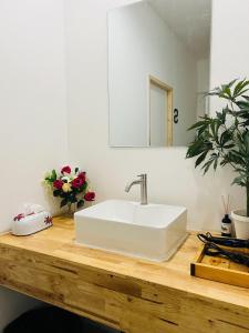 La salle de bains est pourvue d'un lavabo blanc sur un comptoir en bois. dans l'établissement Cannabitel, à Haad Rin