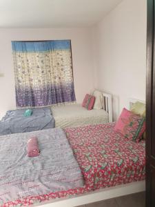 a bedroom with two beds and a mirror at Like Home in Chiang Mai