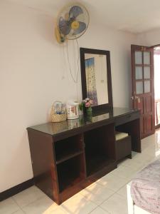 a dressing table with a mirror and a fan at Like Home in Chiang Mai