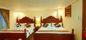 sypialnia z 2 łóżkami z białą pościelą w obiekcie Union Square Hotel w mieście Rangun