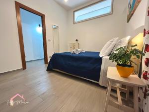 a bedroom with a bed with a blue bedspread and a table at Patty Maison - Large & New Central Apartment in Bari