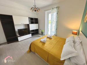 a bedroom with a yellow bed and a television at Patty Maison - Large & New Central Apartment in Bari