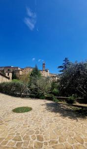 Serra San Quirico的住宿－Fontecorona Bed and Breakfast，石头庭院,后面有一座建筑